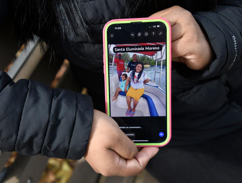 Katiuska Leal Moreno holds a cellphone image of her missing mother on Nov. 4, 2023. Moreno immigrated to the U.S. from Venezuela. Her mother, Santa Eluminada Moreno; sister Greoandis de Los Angeles Moreno; and 4-year-old niece Reyshell Moreno went missing after their boat departed Colombia's San Andres island on Oct. 21, 2023, bound for Nicaragua and never arrived. In the cellphone photo, Santa Eluminada Moreno smiles on a boat in San Andres.