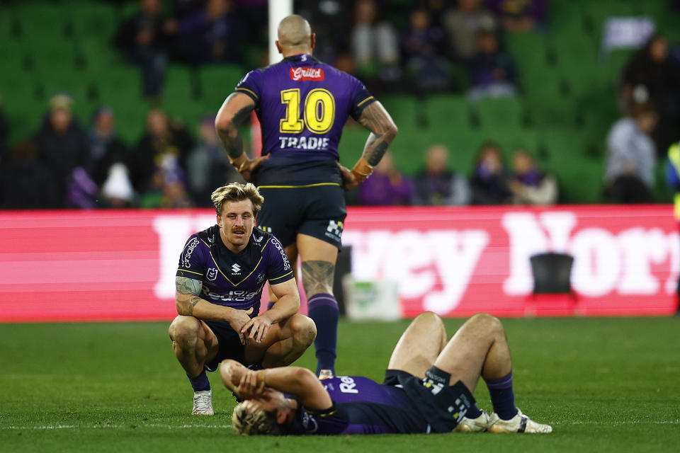 Pictured here, Cameron Munster kneels down next to devastated Melbourne Storm teammates after their elimination final defeat to the Canberra Raiders. 