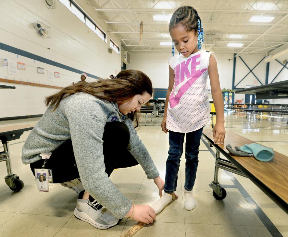 Third year SIU School of Medicine student Molly Smith measures the foot of McClernand Elementary School first grader Cherish Thomas, 6, at the school Tuesday as part of the "Shoes That Fit" program. The medical school has provided more than 1,200 pairs of shoes to area students since 2007.