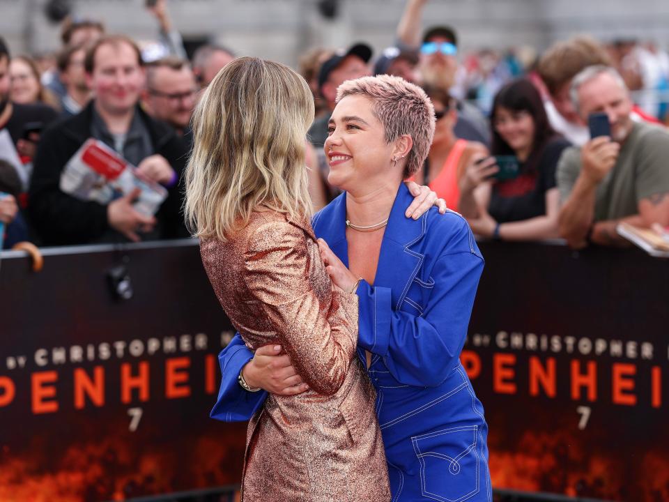 Emily Blunt and Florence Pugh both hold Blunt's blazer closed to prevent a wardrobe malfunction at the London premiere of "Oppenheimer."