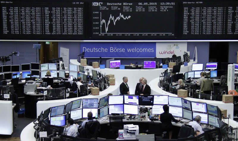 Traders are pictured at their desks in front of the DAX board at the Frankfurt stock exchange, Germany, May 6, 2015. REUTERS/Remote/Staff