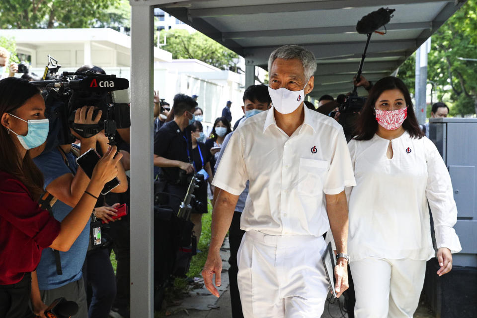 People's Action Party Secretary-General and Singaporean Prime Minister Lee Hsien Loong, center, arrives at a nomination center with his team to submit their nomination papers ahead of the general election in Singapore, Tuesday, June 30, 2020. Campaigning has begun for Singapore’s general elections, with the opposition hoping to dent the ruling party’s supermajority in parliament with support from Prime Minister Lee’s estranged younger brother. (AP Photo/Yong Teck Lim)