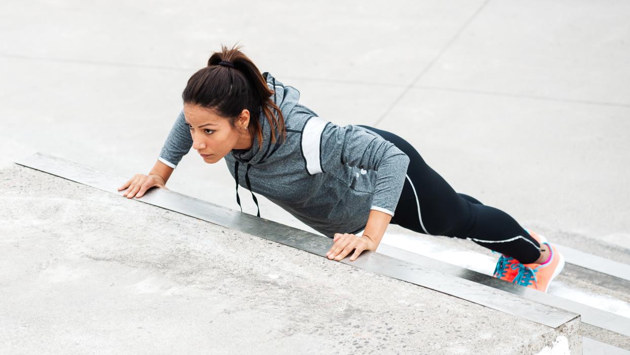  A photo of a woman doing an incline push up. 