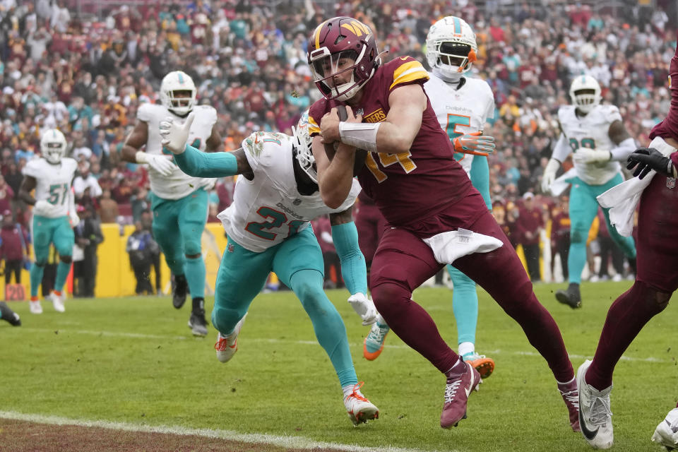 Washington Commanders quarterback Sam Howell (14) runs for a touchdown past Miami Dolphins safety DeShon Elliott (21) during the second half of an NFL football game Sunday, Dec. 3, 2023, in Landover, Md. (AP Photo/Alex Brandon)
