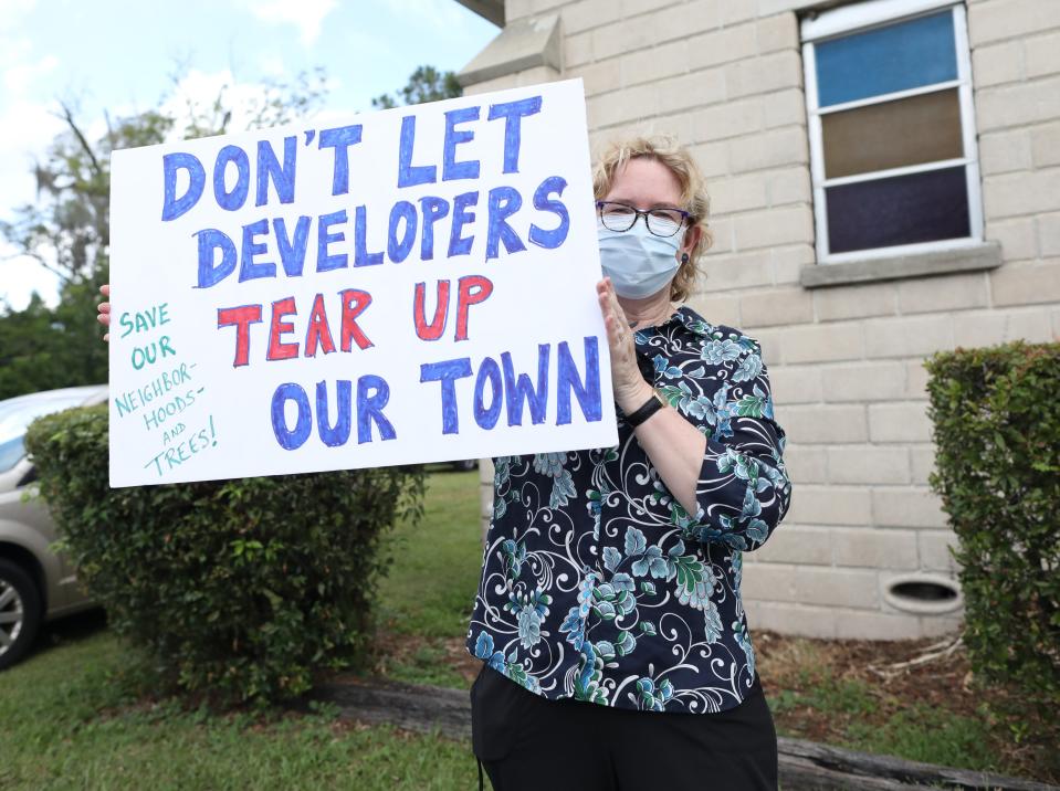 A protestor holds a sign outside a rally against the elimination of single-family zoning throughout the city, at Shady Grove Primitive Baptist Church in Gainesville on Aug. 3.