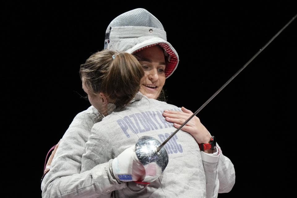 Sofia Pozdniakova, left, Hughs Sofya Velikaya of the Russian Olympic Committee as she celebrates after winning the gold at the women's individual Sabre final competition at the 2020 Summer Olympics, Monday, July 26, 2021, in Chiba, Japan. (AP Photo/Andrew Medichini)