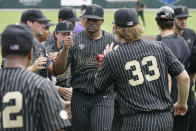 Vanderbilt pitcher Kumar Rocker, center, is congratulated as he walks to the dugout after the third out against East Carolina in the first inning of an NCAA college baseball super regional game Friday, June 11, 2021, in Nashville, Tenn. (AP Photo/Mark Humphrey)