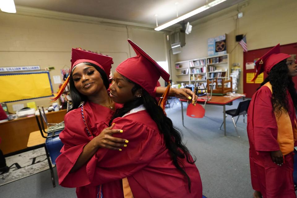 South Delta High valedictorian Kaylyn Davis, right, whose home and school were destroyed in the recent Rolling Fork tornado, hugs her friend Jaqueriah Gibbs, before their graduation ceremony in Anguilla, Miss., Friday, May 19, 2023. (AP Photo/Gerald Herbert)