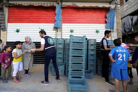 People get bags of bread from a brealine in al-Kalasa district of Aleppo July 13, 2017. REUTERS/ Omar Sanadiki