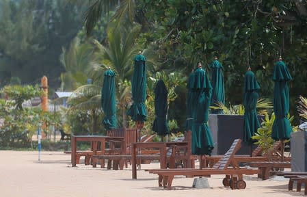 Empty sunbathing chairs are seen near a hotel at Unawatuna beach in Galle