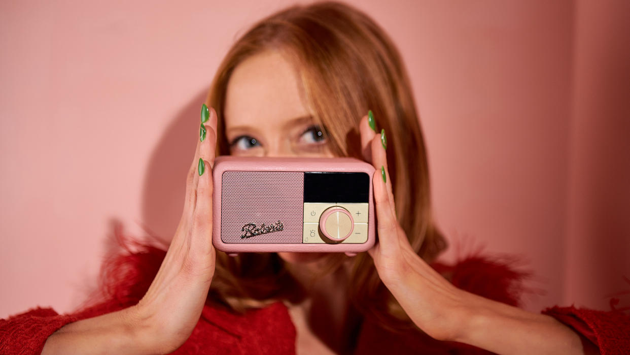  Roberts Revival Petite 2 in pink, held by a redheaded-lady wearing green nail polis, in a pink room. 