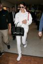 <p>In a white jacket, top and jeans, Nike sneakers, black leather satchel and Dior sunglasses at the Paris airport.</p>