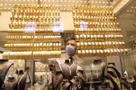 A goldsmith arranges golden bangles at a jewellery shop, in Istanbul