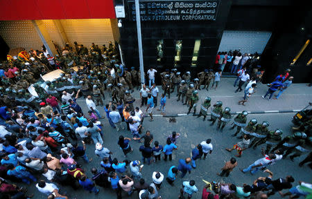 Supporters of Sri Lanka's newly appointed Prime Minister Mahinda Rajapaksa gather as members of the Special Task Force and the police stand guard after an official security guard of sacked minister Arjuna Ranatunga shot and wounded three people in front of the Ceylon Petroleum Corporation, in Colombo, Sri Lanka October 28, 2018. REUTERS/Dinuka Liyanawatte