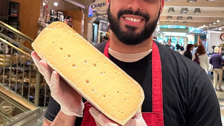 Murray's Cheese employee holding cheese