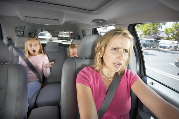 Mother driving car, two children (8-10) sitting in back seat