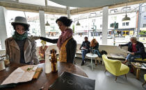 Display mannequins are placed between customers at the Cafe Livres in Essen, Germany, Wednesday, May 20, 2020. The cafe set the dolls as placeholders on various places for more distance between customers due to the new coronavirus orders for restaurants and cafes. (AP Photo/Martin Meissner)