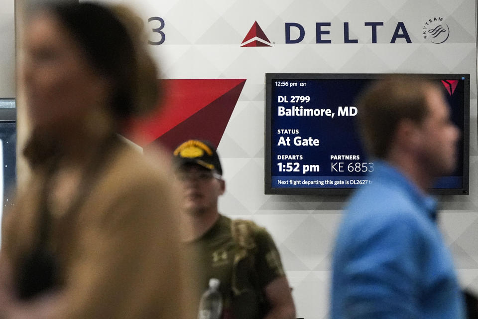 FILE - Travelers move through the terminal near a Delta Airlines desk at Hartsfield-Jackson Atlanta International Airport, Jan. 27, 2024, in Atlanta. On Thursday, July 11, 2024, Delta Air Lines said its second-quarter profit is down 29% from a year earlier, and it's giving a disappointing outlook for the third quarter. (AP Photo/Mike Stewart, File)