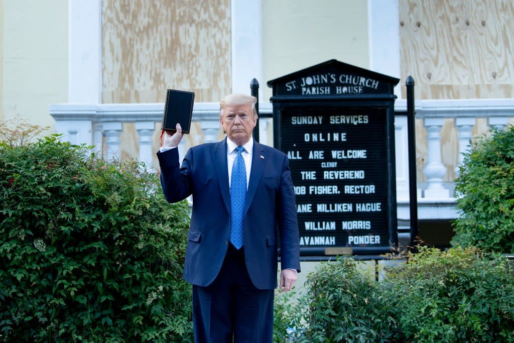 Donald Trump poses with a Bible that isn’t his outside St John’s Episcopal Church in Washington amid racial justice protests on 1 June. (AFP via Getty Images)