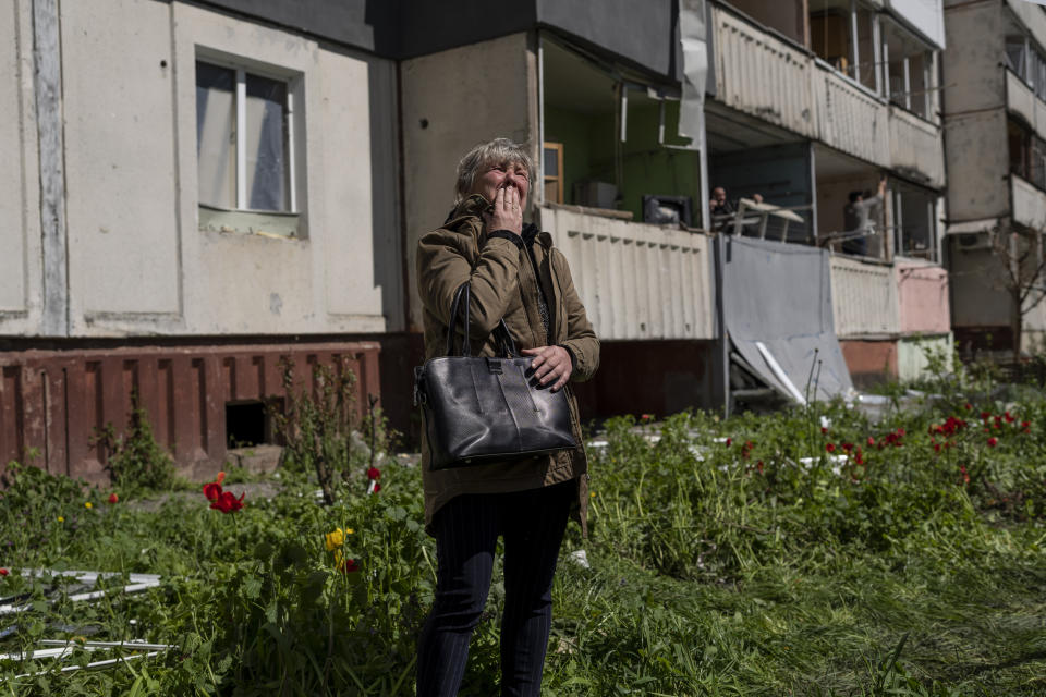 A woman cries as she watches the destruction of a residential building that was hit during a Russian attack in Uman, central Ukraine, Friday, April 28, 2023. (AP Photo/Bernat Armangue)