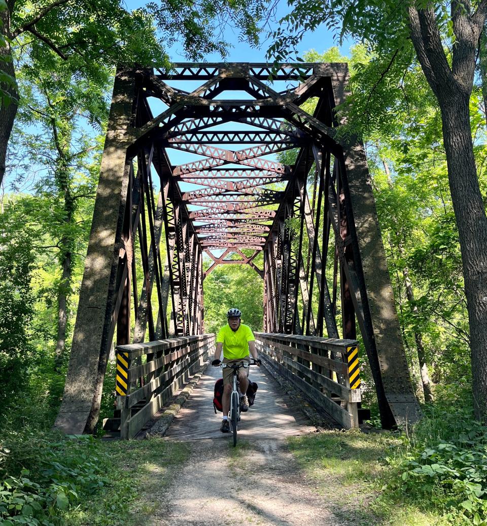 John Gurda rides over a bridge on the La Crosse Trail as he begins a bike ride across Wisconsin.