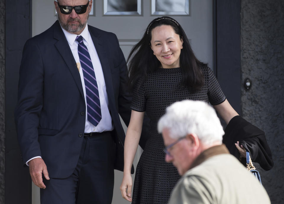 FILE - In this May 8, 2019, file photo, Huawei Chief Financial Officer Meng Wanzhou, back right, who is out on bail and remains under partial house arrest leaves her home to attend a court appearance in Vancouver, British Columbia. China on Thursday, Sept. 5, 2019, has urged Canada to "reflect on its mistakes" and immediately release a Huawei executive detained in Vancouver. (Darryl Dyck/The Canadian Press via AP, File)