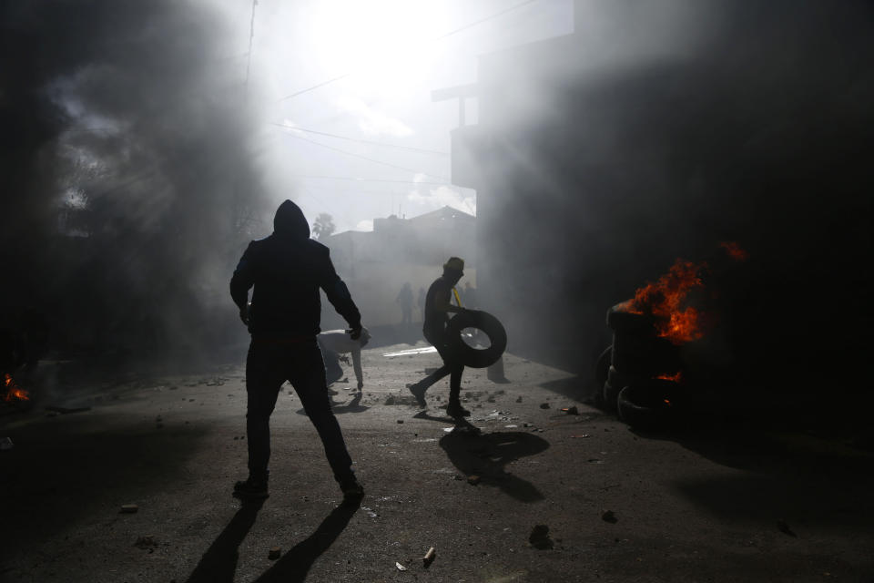 Palestinians burn tires during clashes with Israeli soldiers after the funeral of policeman Tariq Badwan in the West Bank village of Azoun near Qalqilya, Friday, Feb. 7, 2020. Badwan was shot while standing at the entrance of a police station in Jenin, where Israeli forces clashed with Palestinians while demolishing the home of an alleged militant. He did not appear to have been involved in the clashes. (AP Photo/Majdi Mohammed)