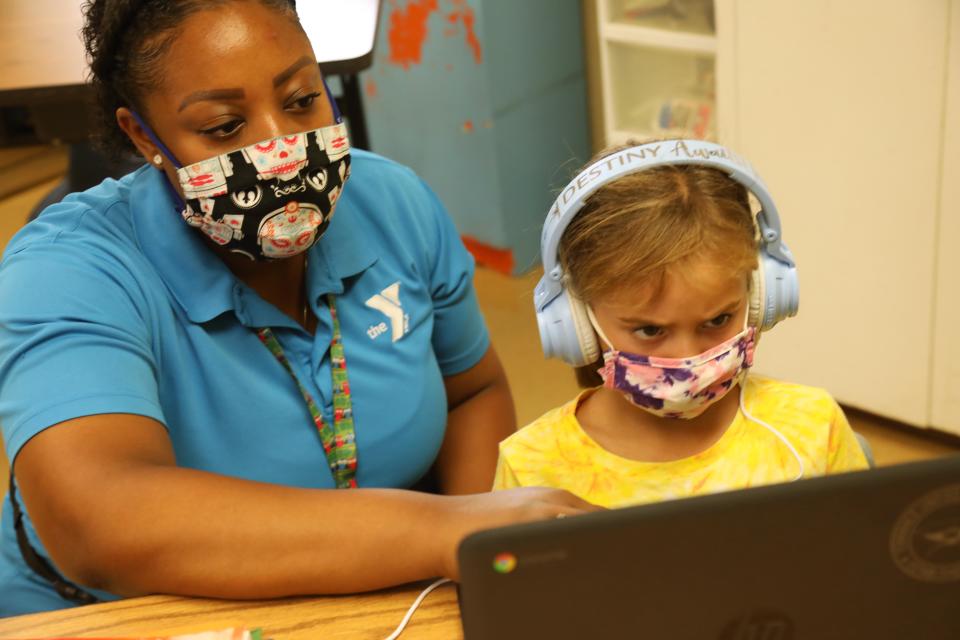 TORRANCE, CA - SEPTEMBER 17, 2020 - - Denecia Boone, left, a teacher with the YMCA, helps Maya Haldeman with an exercise at the Anza Elementary School campus in Torrance on September 17, 2020. Anza Elementary School is one of many schools that are reformatting and rebranding as camps, enrichment programs and daycare, bringing students back to closed campuses for a fee. Torrance Unified School District is one of many that now offers fee-based, in person enrichment for its elementary school students, through the YMCA. (Genaro Molina / Los Angeles Times via Getty Images)