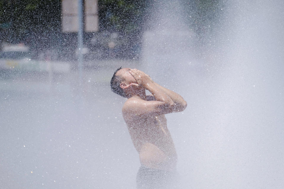 A man cools off in Salmon Street Springs downtown Portland, Ore., on Monday. (Alex Milan Tracy / Sipa USA via AP)