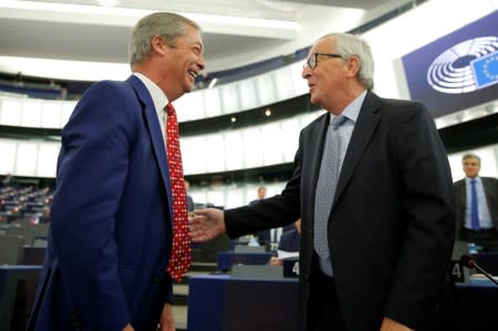 European Commission President Jean-Claude Juncker talks with Brexit Party leader Nigel Farage before a debate on Brexit at the European Parliament in Strasbourg