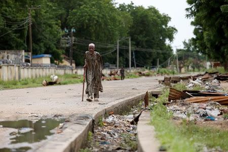 An elderly man walks along a nearly empty street, opposite the Nigeria Air Force hospital in Bama, Borno, Nigeria, August 31, 2016. REUTERS/Afolabi Sotunde