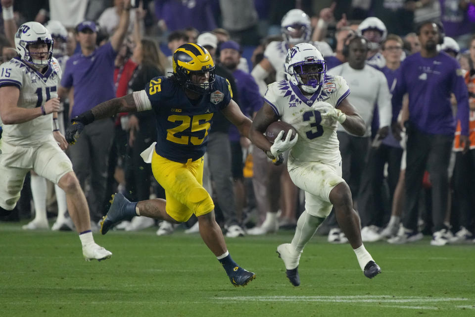 TCU running back Emari Demercado (3) breaks free from Michigan linebacker Junior Colson (25) during the second half of the Fiesta Bowl NCAA college football semifinal playoff game, Saturday, Dec. 31, 2022, in Glendale, Ariz. (AP Photo/Rick Scuteri)