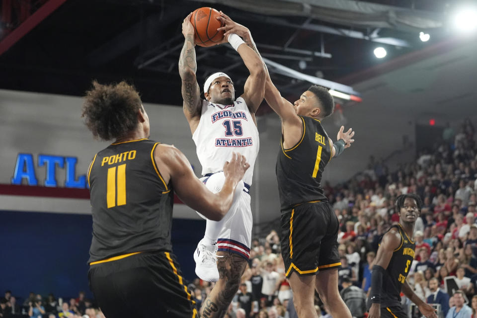 Florida Atlantic guard Alijah Martin (15) drives to the basket as Wichita State guard Xavier Bell (1) and forward Kenny Pohto (11) defend during the first half of an NCAA college basketball game, Thursday, Jan. 18, 2024, in Boca Raton, Fla. (AP Photo/Marta Lavandier)