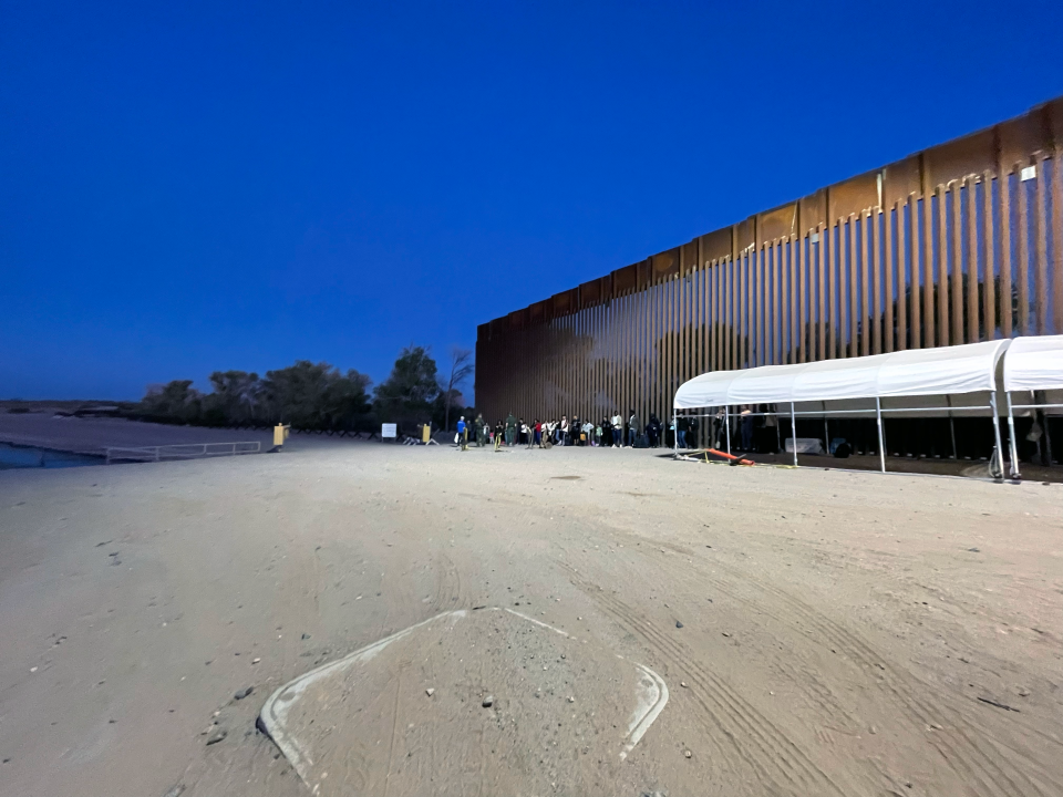 Families and adults from China, Colombia, Senegal and other countries wait to be transported by Border Patrol near Yuma, Arizona, after crossing into the U.S. before sunrise. / Credit: Camilo Montoya-Galvez/CBS News