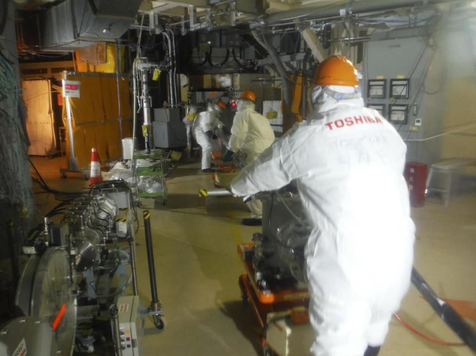 In this photo released by Tokyo Electric Power Co. (TEPCO), workers prepare to operate a remote-controlled "cleaning" robot at Unit 2 of Fukushima Dai-ichi nuclear power plant in Okuma town, Fukushima prefecture, northeastern Japan, Thursday, Feb. 9, 2017. The "cleaning" robot that entered one of three tsunami-wrecked Fukushima reactor containment chambers was withdrawn before completing its mission due to glitches most likely caused by high radiation. (TEPCO via AP)