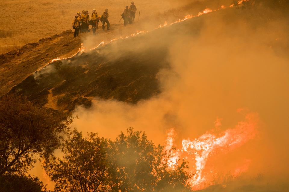 Fire crews maintain a backburn to control the River Fire near the Las Palmas neighborhood in Salinas, Calif., Wednesday, Aug. 19, 2020.