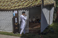 Umar Fayaz, a Kashmiri boy wears a mask before entering a tent at a wedding on the outskirts of Srinagar, Indian controlled Kashmir, Thursday, Sept. 17, 2020. The coronavirus pandemic has changed the way people celebrate weddings in Kashmir. The traditional week-long feasting , elaborate rituals and huge gatherings have given way to muted ceremonies with a limited number of close relatives attending. With restrictions in place and many weddings cancelled, the traditional wedding chefs have little or no work. The virus has drastically impacted the life and businesses in the region. (AP Photo/ Dar Yasin)