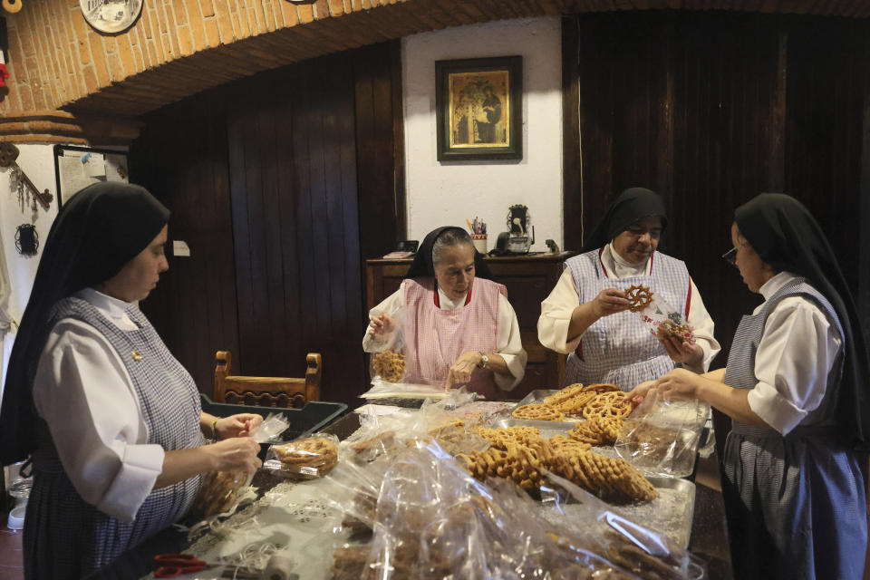 Desde la izquierda, las monjas Alejandra Jaime, de 39 años, María Inés Maldonado, de 76, María Auxiliadora Estrada, de 59, y Patricia Marín, de 28, empaquetan los dulces navideños en bolsas de plástico para venderlos en el convento de las Adoratrices Perpetuas del Santísimo Sacramento, en Ciudad de México, el jueves 7 de diciembre de 2023. (AP Foto/Ginnette Riquelme)