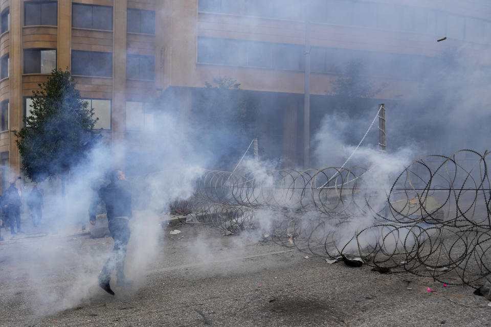 Retired members of the Lebanese security and other protesters return tear gas canisters towards riot police during a protest demanding better pay in Beirut, Lebanon, Wednesday, March 22, 2023. Lebanese security forces fired tear gas to disperse hundreds of protesters who tried to break through the fence leading to the government headquarters in downtown Beirut Wednesday amid widespread anger over the harsh economic conditions in the country. (AP Photo/Hassan Ammar)