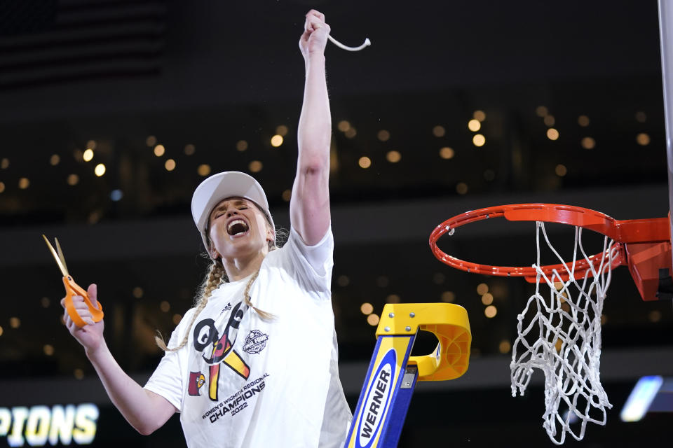 FILE - Louisville guard Hailey Van Lith (10) celebrates after help cut the net down after beating Michigan 62-50 in a college basketball game in the Elite 8 round of the NCAA women's tournament Monday, March 28, 2022, in Wichita, Kan. Some star women’s players have already decided to stay in school rather than make their earliest possible jump to the WNBA and more are on the way with NIL deals and chartered travel offering appeal compared to rookie salaries and commercial flights in the WNBA. (AP Photo/Jeff Roberson, File)