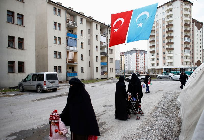 FILE PHOTO: Uyghur refugee women walk where they are housed in a gated complex in the central city of Kayseri, Turkey