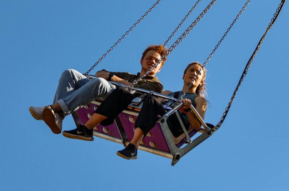 Tribune reporters John Lynch and Chloe Jones ride the Vertigo Swings during a visit to the Mid-State Fair on July 20, 2023.