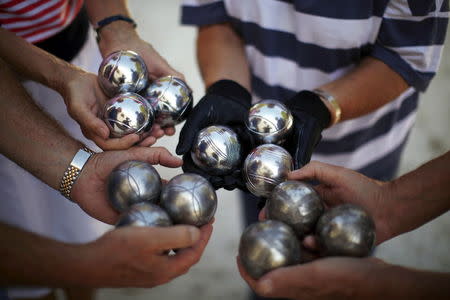 British migrants show petanque balls as they play boules at The British Society in Benalmadena, near Malaga, southern Spain, September 30, 2015. REUTERS/Jon Nazca