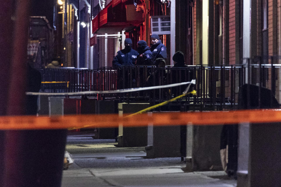 New York Police officers are seen at the scene of a shooting in Harlem on Friday, Jan. 21, 2022, in New York. A New York police officer was killed and another critically wounded while answering a call about an argument between a woman and her adult son, officials said, making four officers shot in the city in as many days. (AP Photo/Yuki Iwamura)