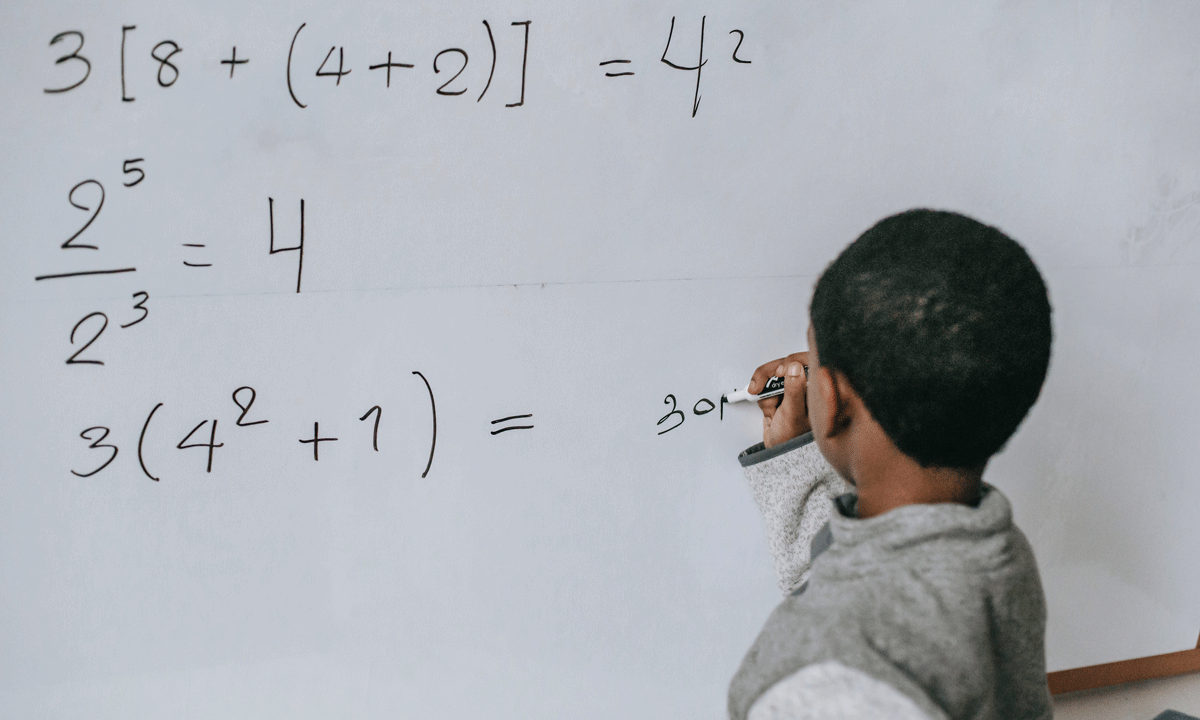 A student doing math on a whiteboard