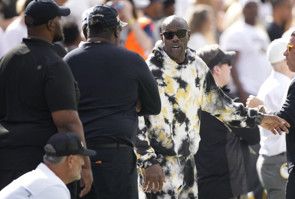 Retired NFL wide receiver Terrell Owens, right, chats with other attendees as Colorado hosts Southern California in the first half of an NCAA college football game, Saturday, Sept. 30, 2023, in Boulder, Colo. (AP Photo/David Zalubowski)