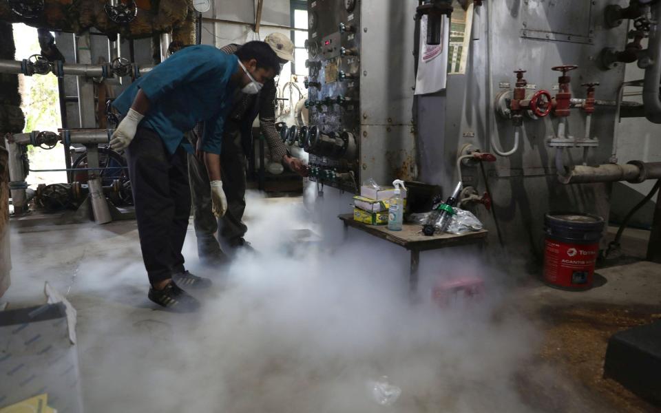 Workers refilling oxygen cylinders at a gas supplier facility in Srinagar, the summer capital of Indian Kashmir - FAROOQ KHAN/EPA-EFE/Shutterstock 