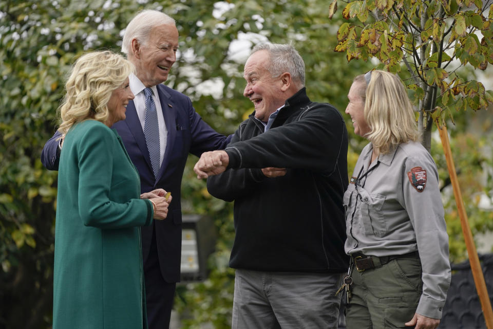 Dale Haney, the chief White House groundskeeper, second from right, laughs as he stands with President Joe Biden and first lady Jill Biden during a tree planting ceremony on the South Lawn of the White House, Monday, Oct. 24, 2022, in Washington. As of this month, Haney has tended the lawns and gardens of the White House for 50 years. (AP Photo/Evan Vucci)