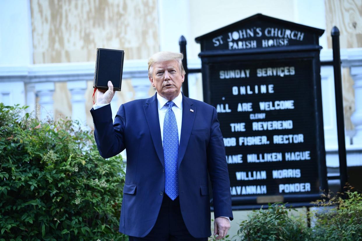 Donald Trump holds up a Bible after walking to St John Episcopal Church. Demonstrators protesting against the killing of George Floyd were cleared from Lafayette Park with tear gas so that he could walk to the church from the nearby White House: AFP via Getty Images