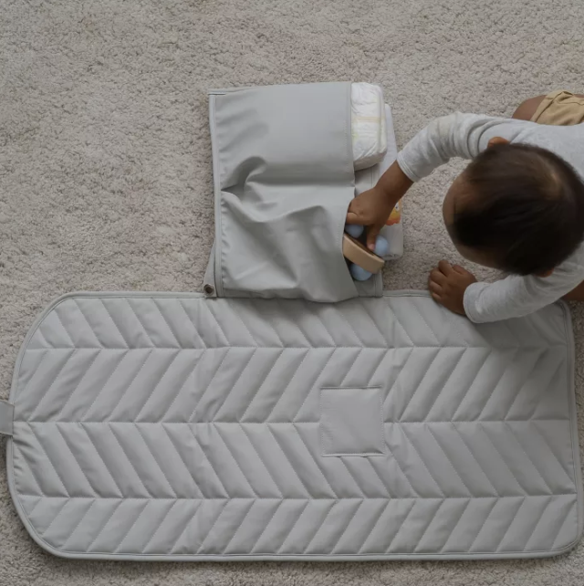 A photo of a baby on a Ted & Luna Diaper Changing Mat.